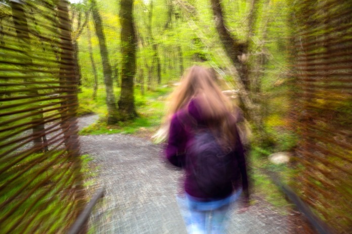A woman in motion hiking on the Falls of Falloch trail